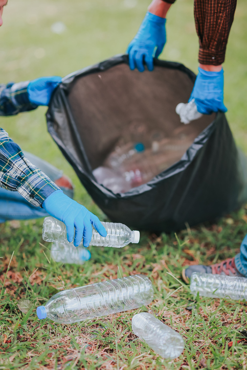 Man collecting garbage Volunteer to collect plastic bottles in black bags Clean the park, avoid pollution, be friendly to the environment.